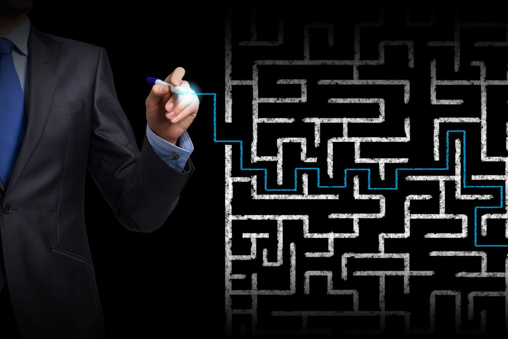 Close up of businessman drawing way out of labyrinth